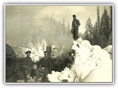 V ery narrow valley. We were cutting an oldl log jam that turned the river against our road and was washing  it away. Bill Whitley on top of snow pile.